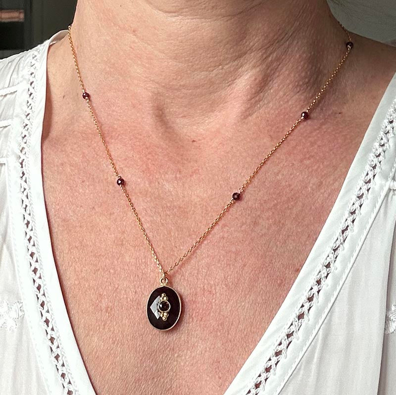 Gold plated chain necklace with faceted garnet set in oval shape