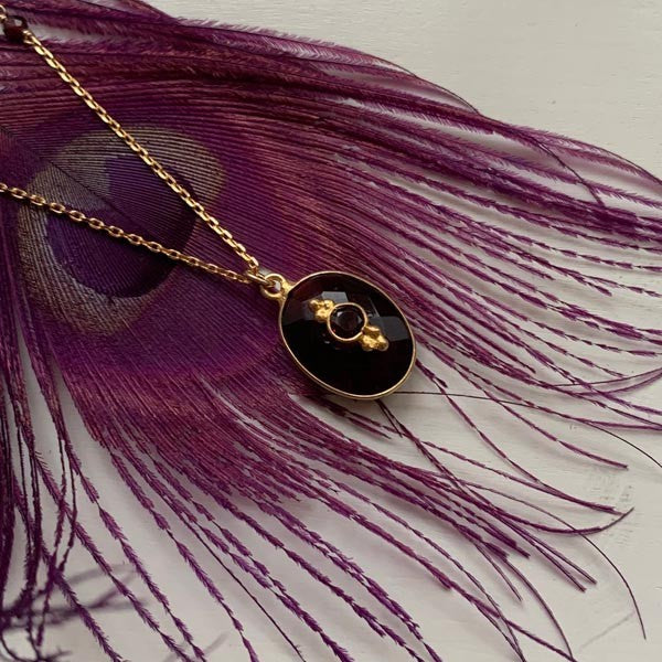 Gold plated chain necklace with faceted garnet set in oval shape