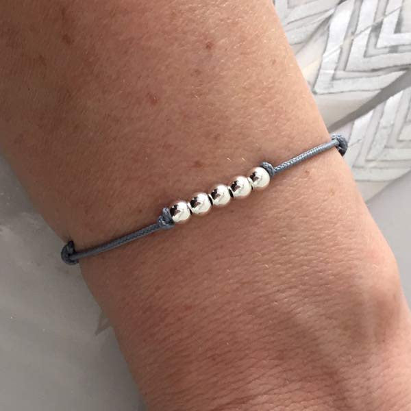 Cord bracelet with 5 small smooth silver beads