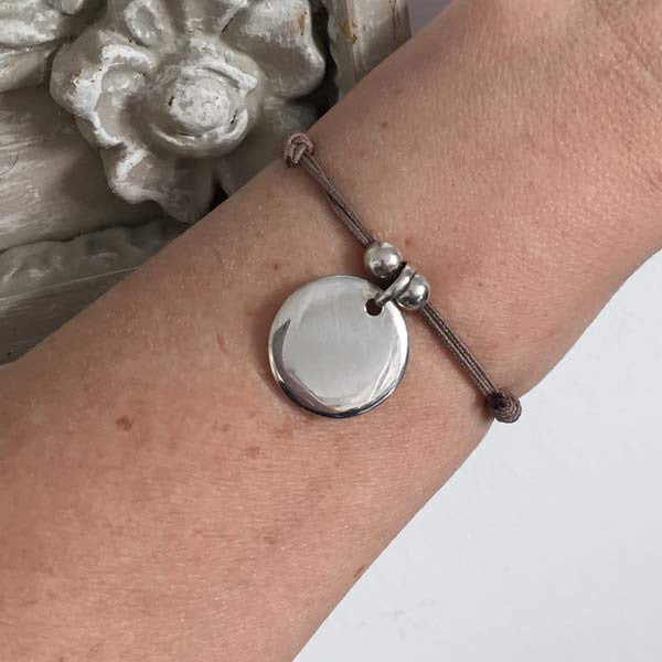 Cord bracelet with round silver medal beads