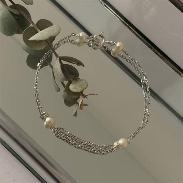 Triple silver chain bracelet with small white freshwater pearls 