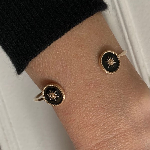 Fine gold-plated bangle bracelet with 2 black star beaded discs